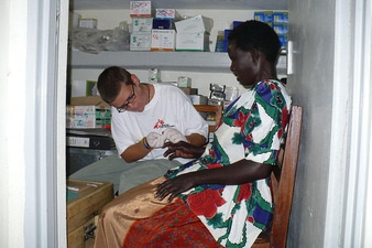 Kellie Lamoreau '97, conducts a paracheck (Malaria test) on a patient in Uganda.